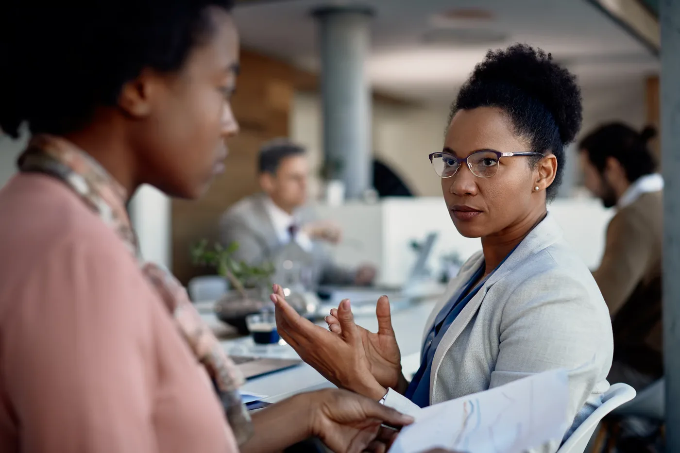 Two colleagues discussing conflict resolution in the workplace
